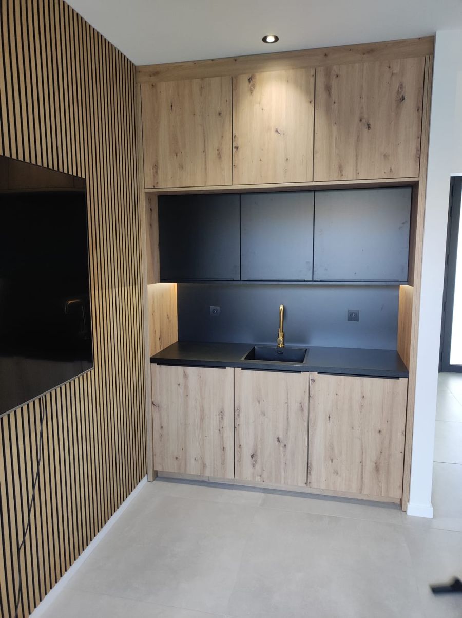 Keukenrenovatie met houten lamellen en zwart werkblad — Badpaleis